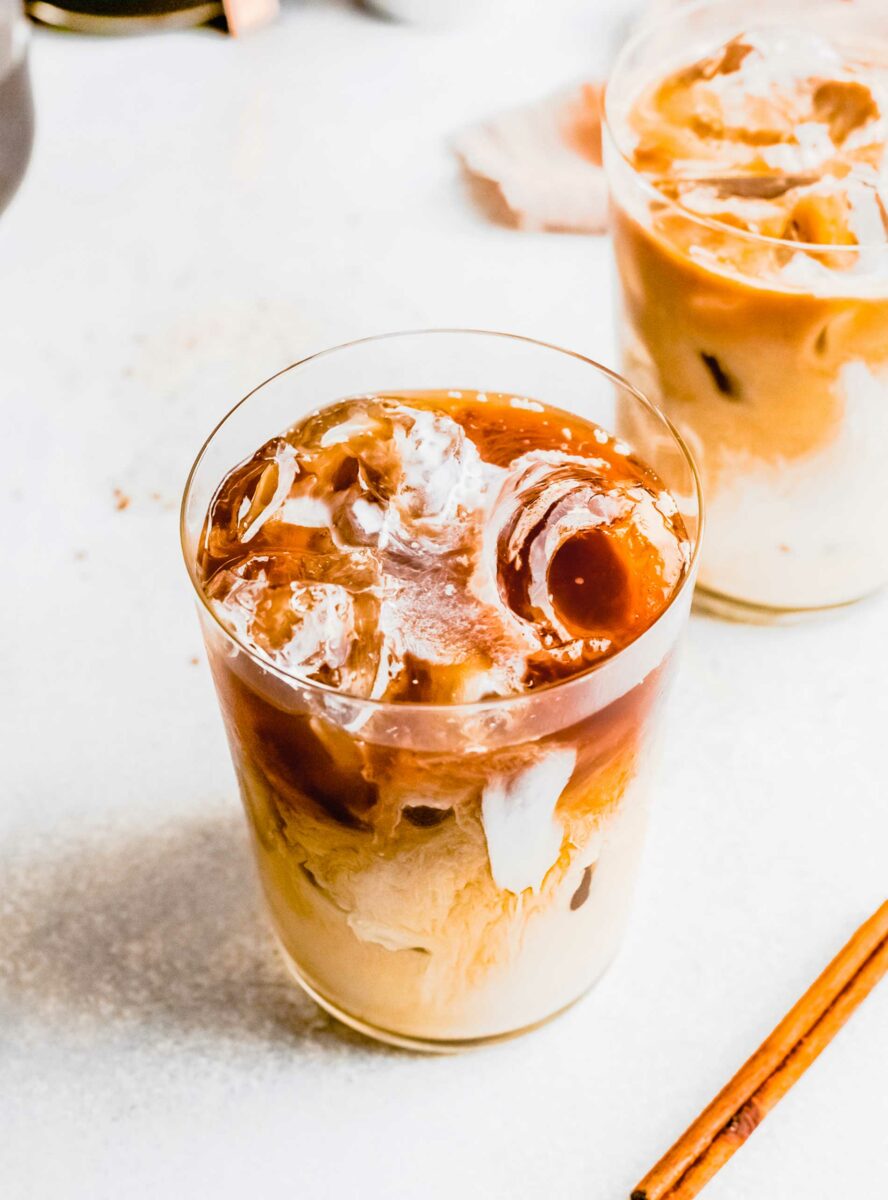 Ice cubes are floating in a glass of espresso. 