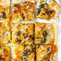 Extra buffalo sauce has ben drizzled onto a flatbread with a small spoon.