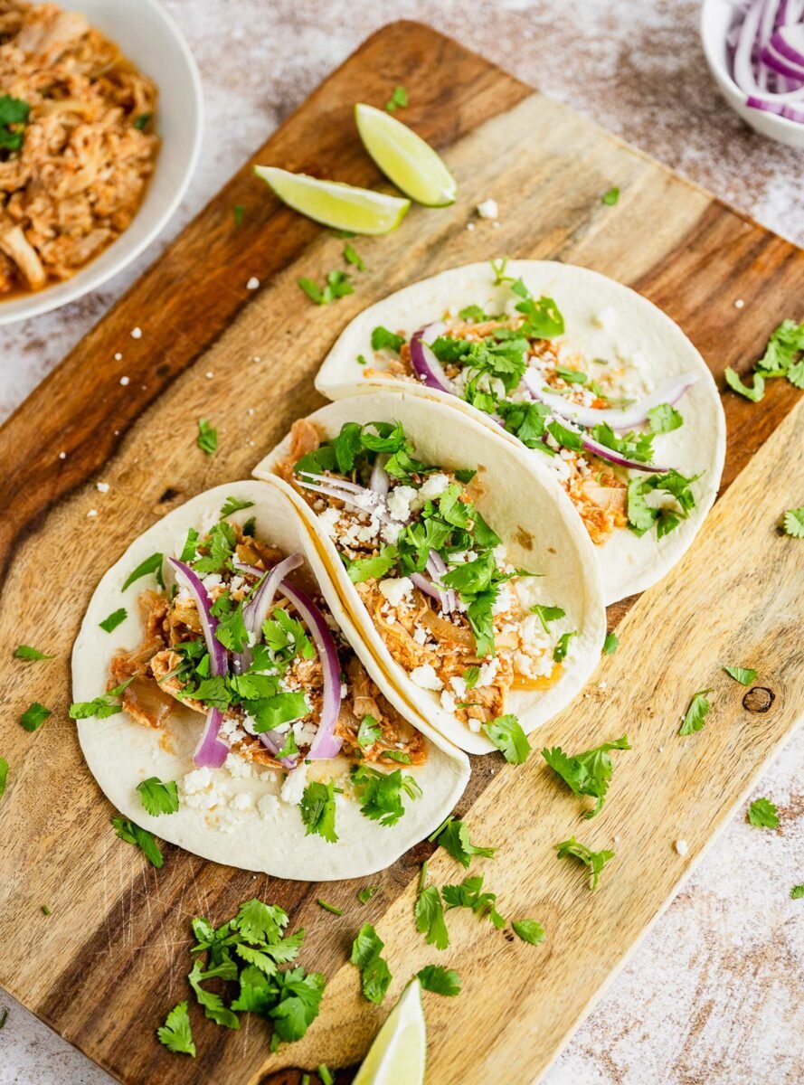 Cilantro is spread over three tacos. 