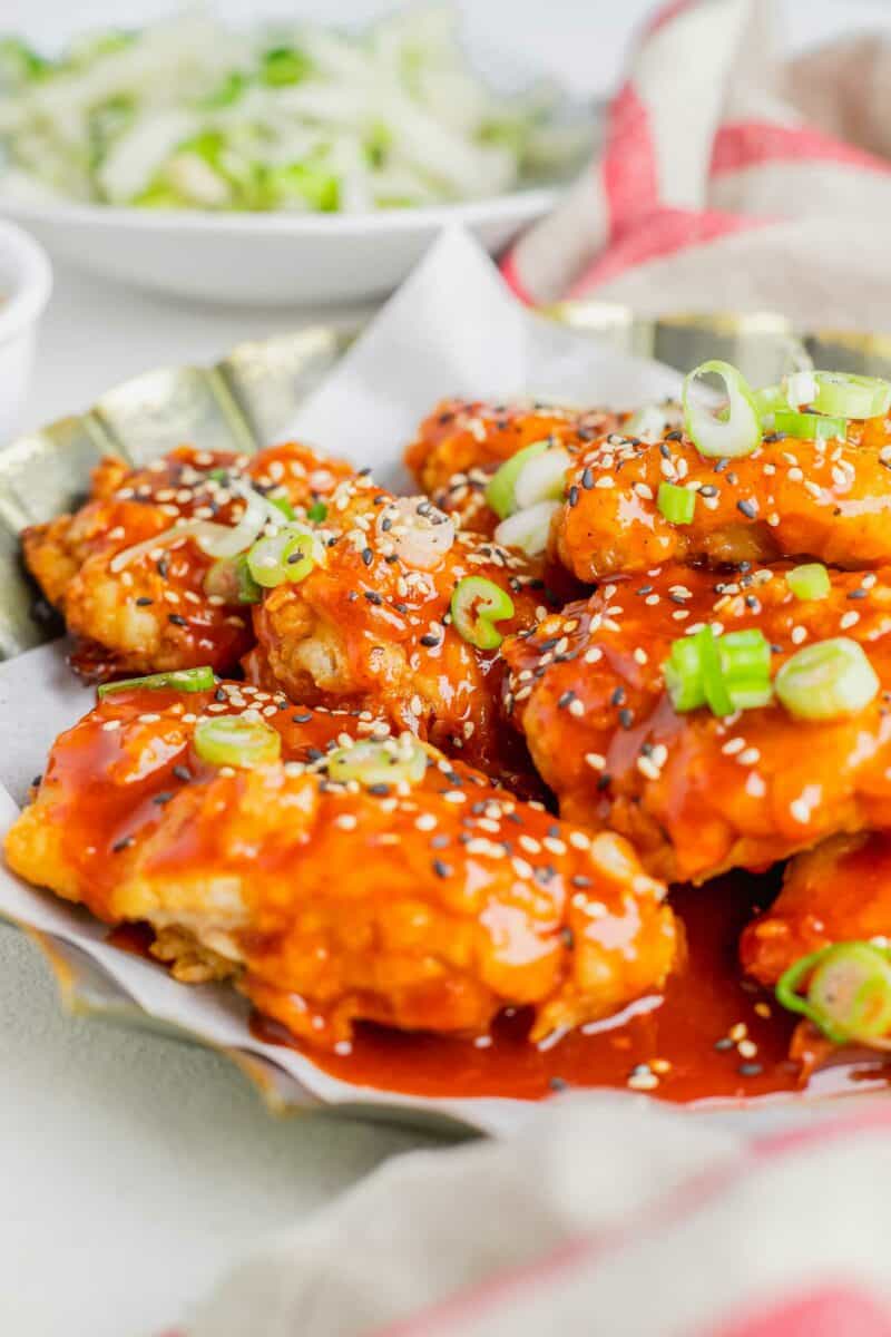 Vibrant orange sauce covers cooked chicken thighs. 