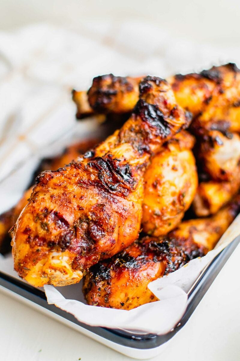 Grilled chicken legs are placed on a sheet of parchment paper. 