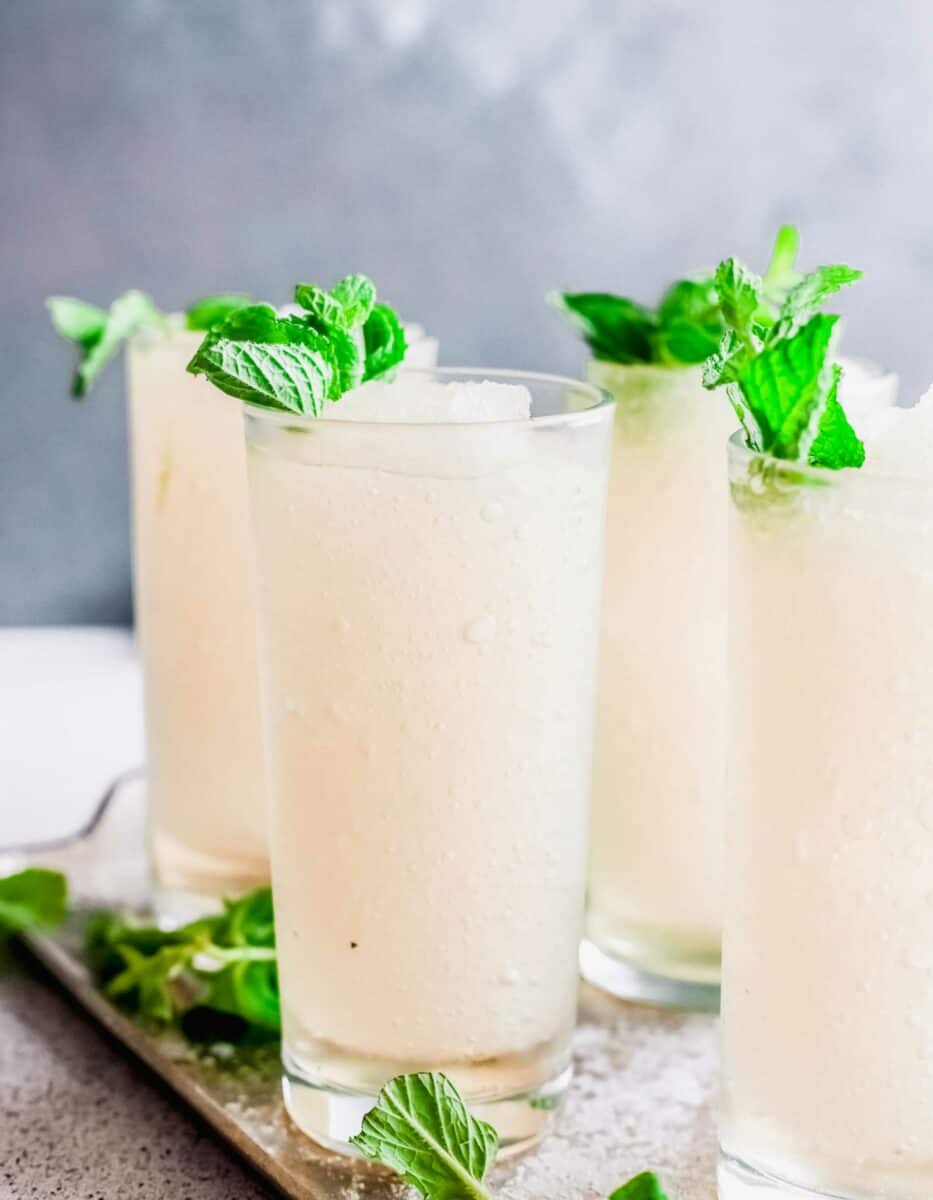 Four frozen mint juleps are placed on a serving tray.