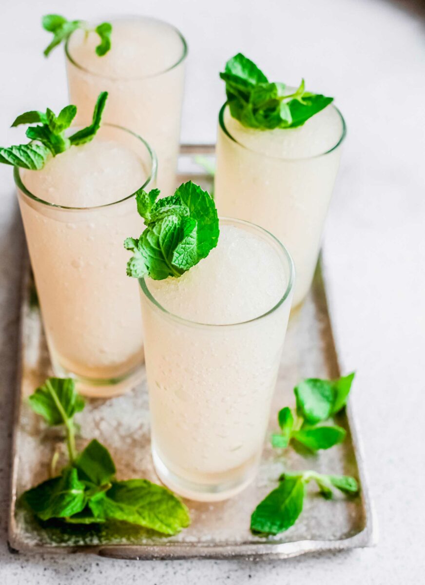 Mint sprigs sit on top of frozen cocktails. 