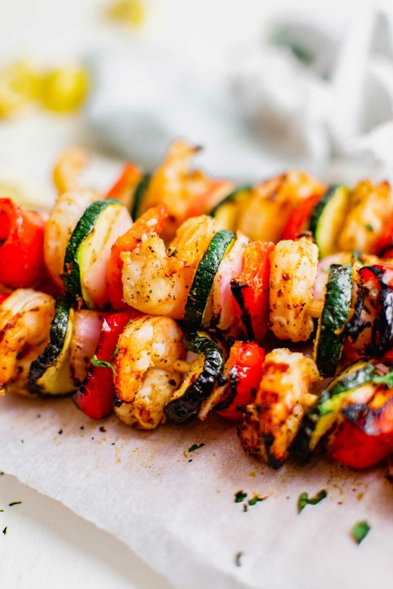 Grilled kebobs are placed on top of each other. 