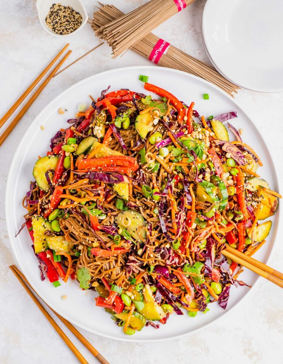 A large plate os soba noodle salad is garnished with sesame seeds. 