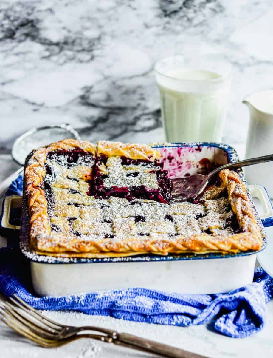 A spatula is lifting a piece of pie from the baking dish. 