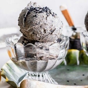 Two scoops of black sesame ice cream are in a small glass bowl.