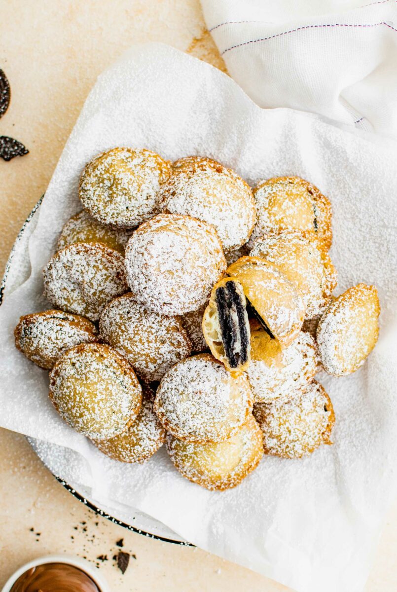 A basket of deep fried Oreos has been sprinkled liberally with powdered sugar. 