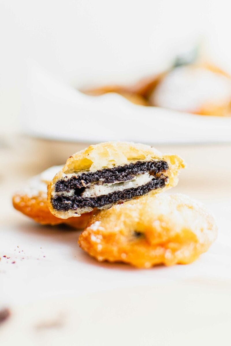 Three fried Oreos are placed on a white surface. 