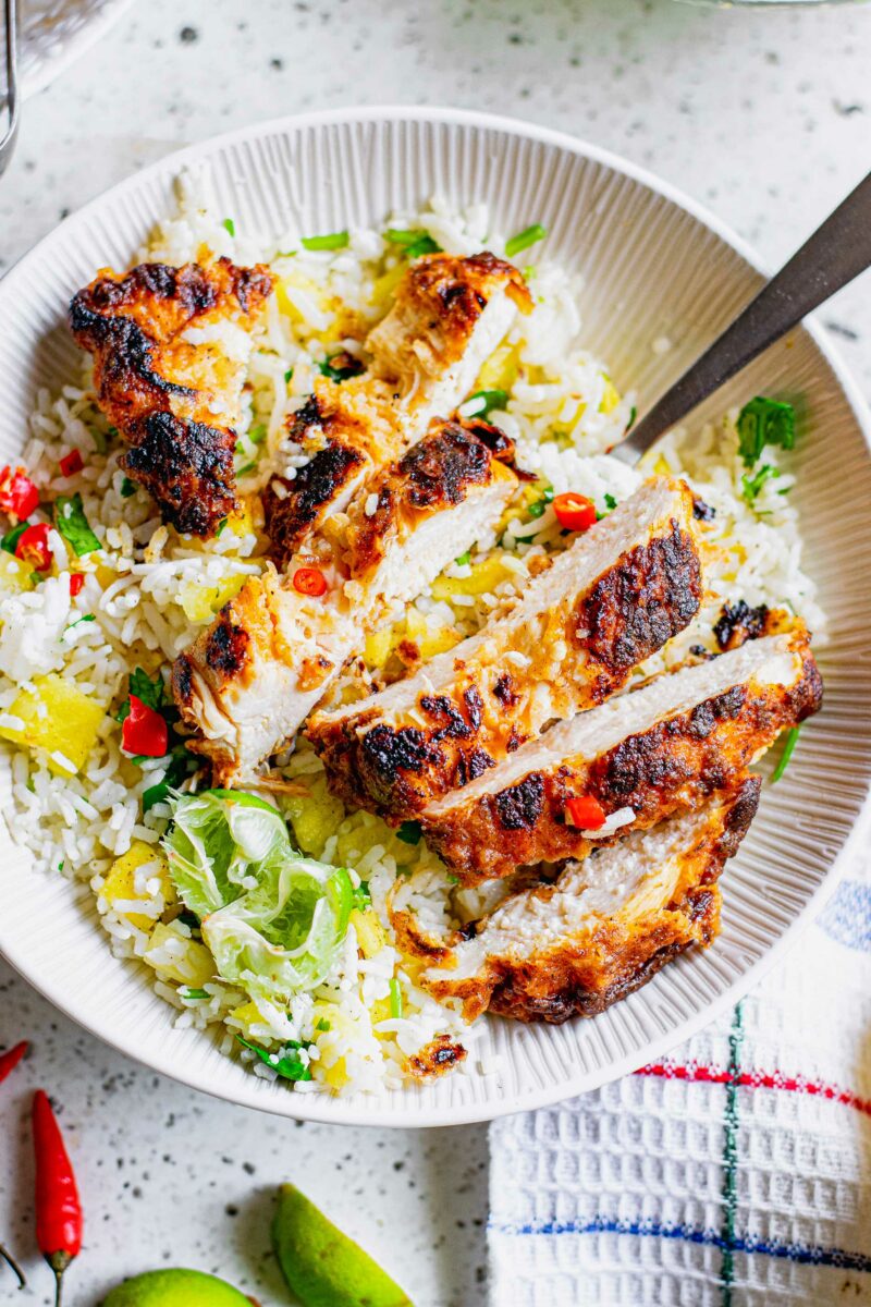 Chicken and rice is mixed together in a white bowl. 