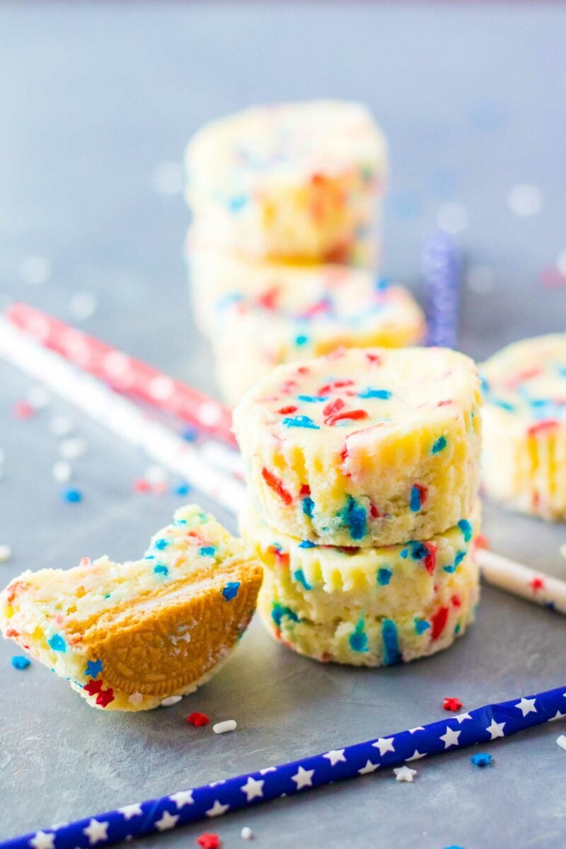 A blue starred straw is placed next to a pile of mini cheesecakes. 