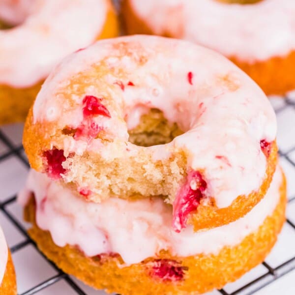 Several donuts are placed on a wire cooling rack.