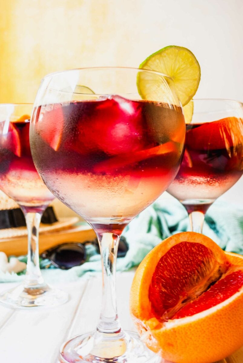 Three glasses of Tinto de Verano are placed on a white surface. 