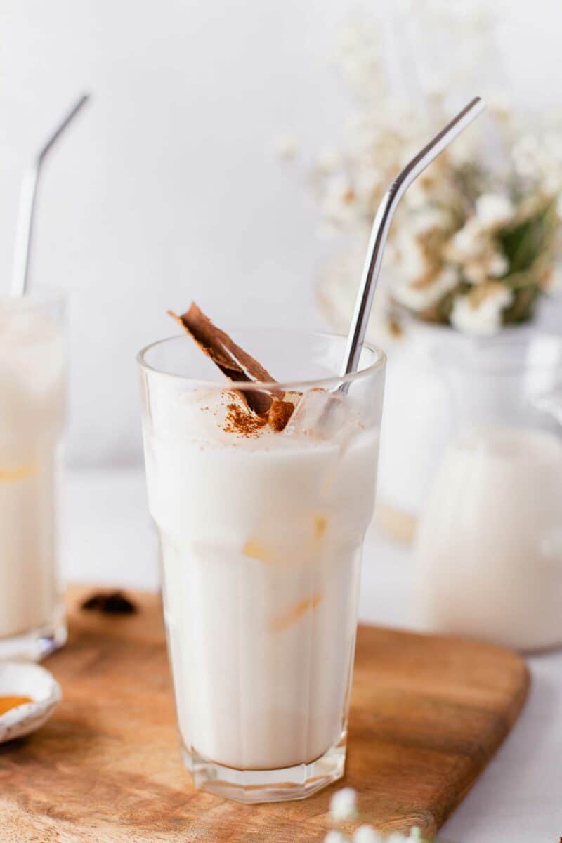 A metal straw is placed in a glass cup filled with horchata. 