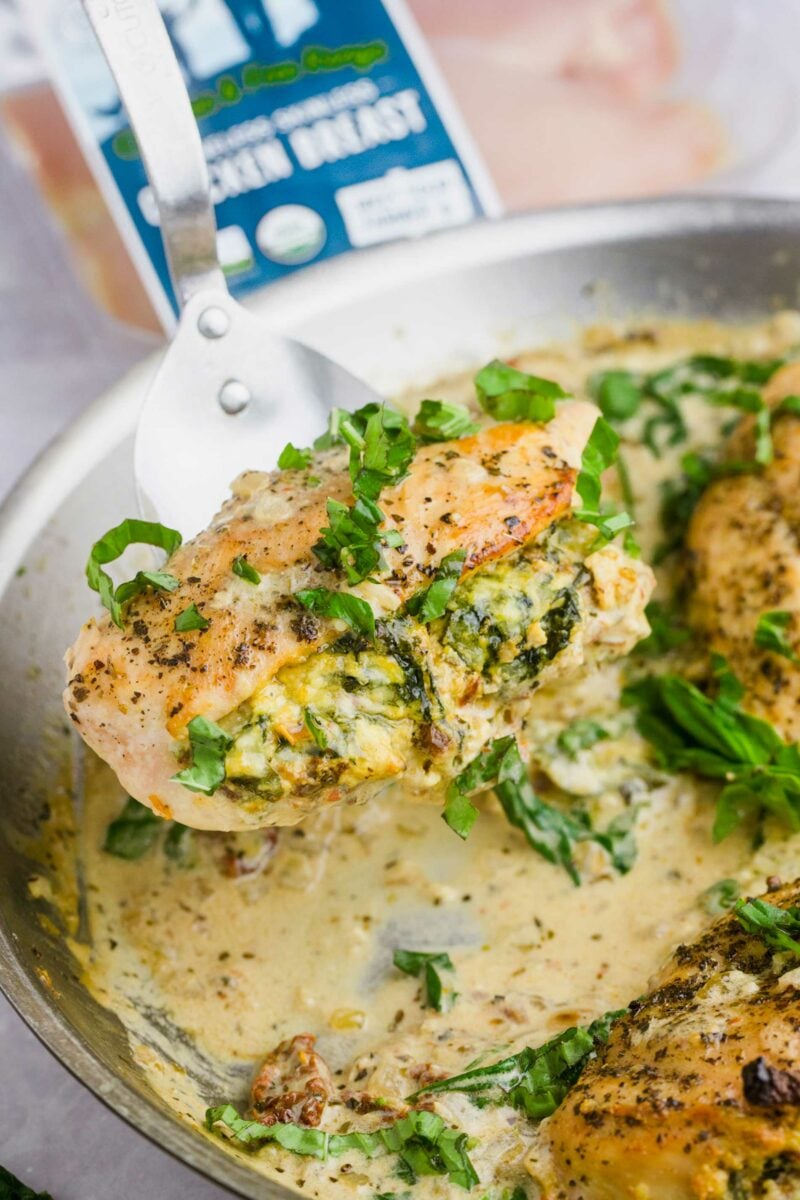 A chicken breast has been lifted from the skillet.