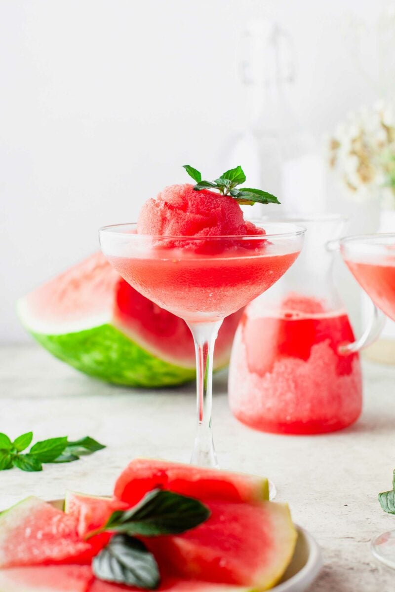 A glass of frosé is garnished with a mint sprig.