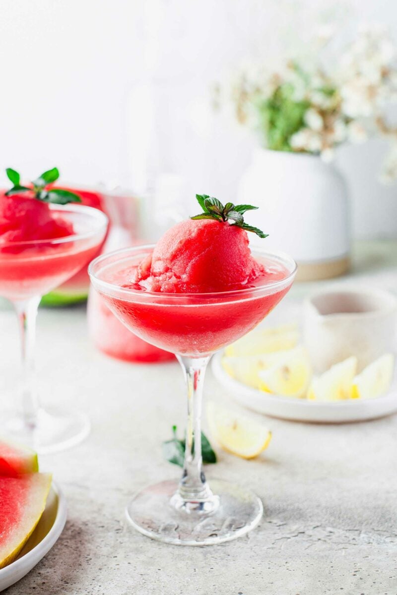 A martini glass is filled with watermelon frose. 