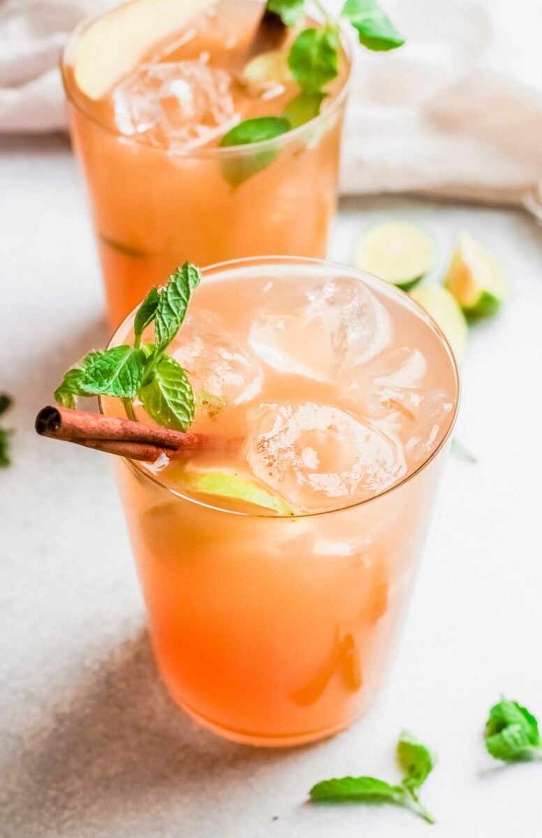 A mojito is garnished with a mint sprig and a cinnamon stick. 