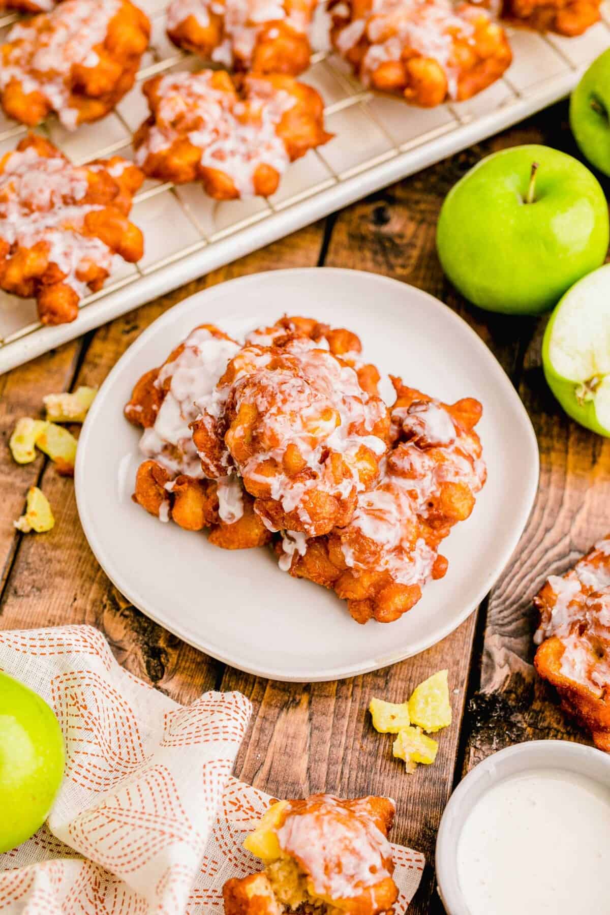 Several glazed fritters are placed on a white plate.