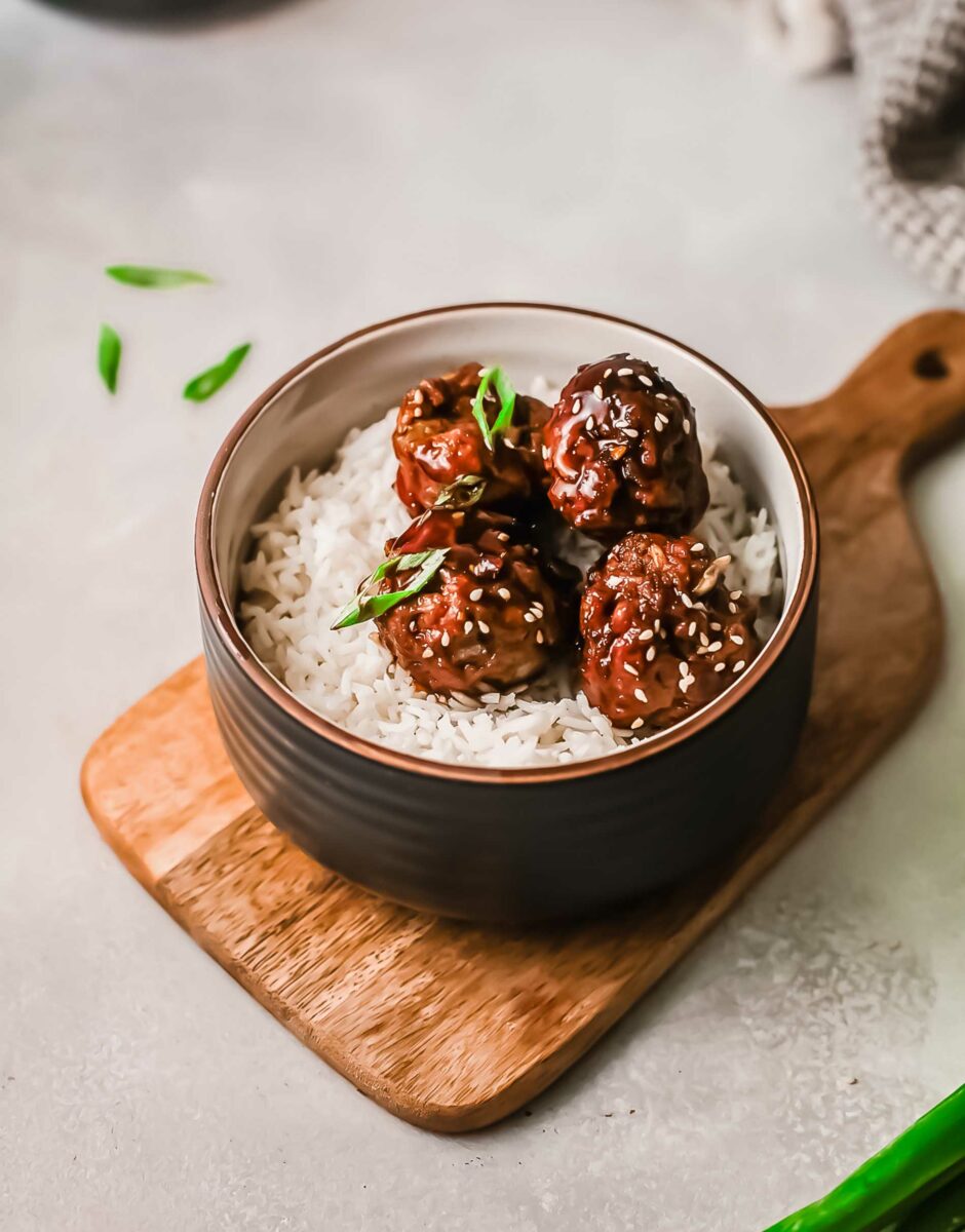 Several meatballs are placed on a bed of white rice. 