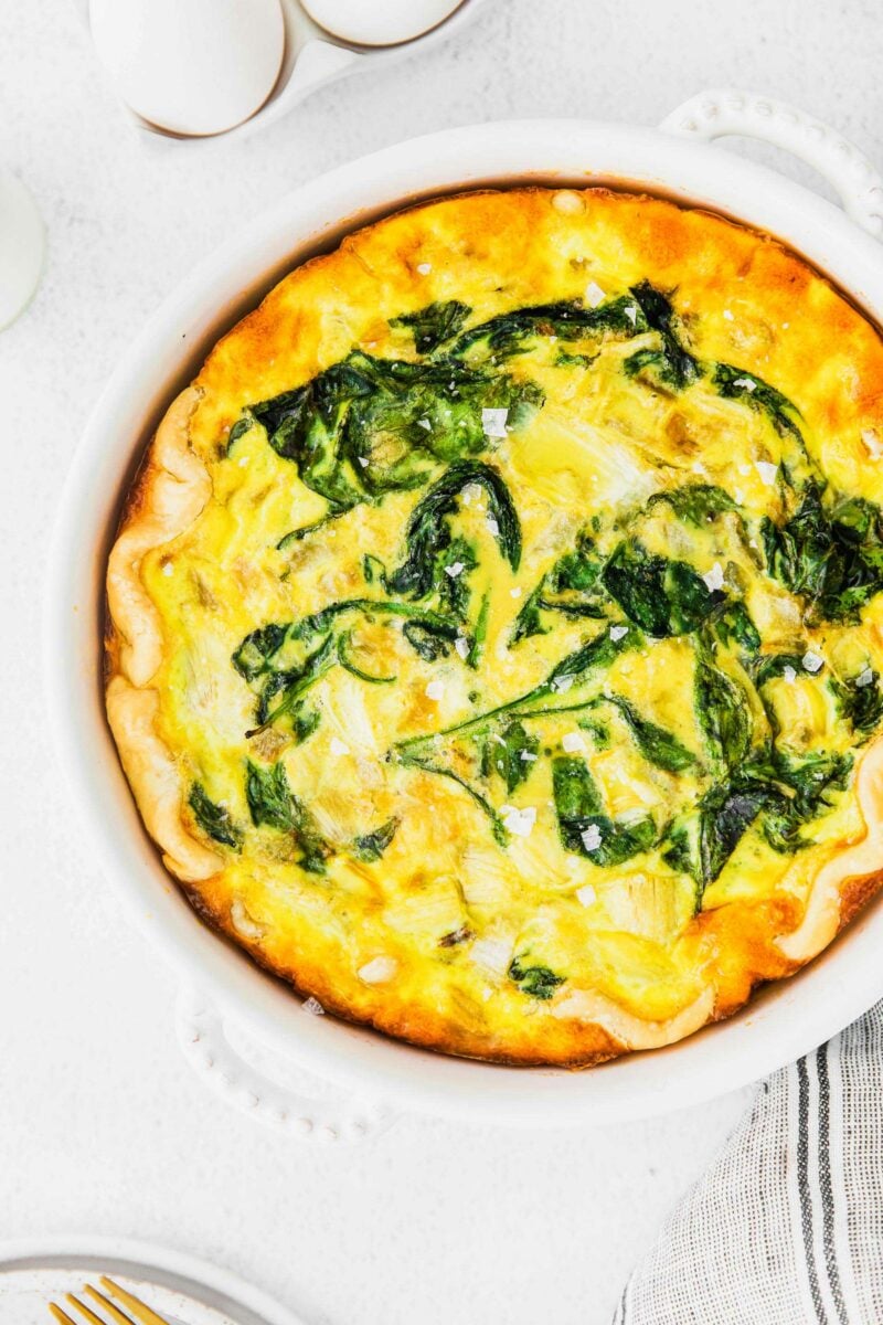 A baked quiche is topped with flaky sea salt. 