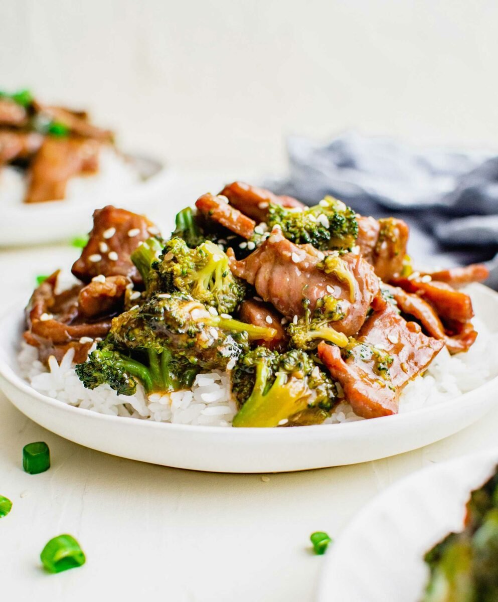 White rice, broccoli and beef are presented on a white plate. 