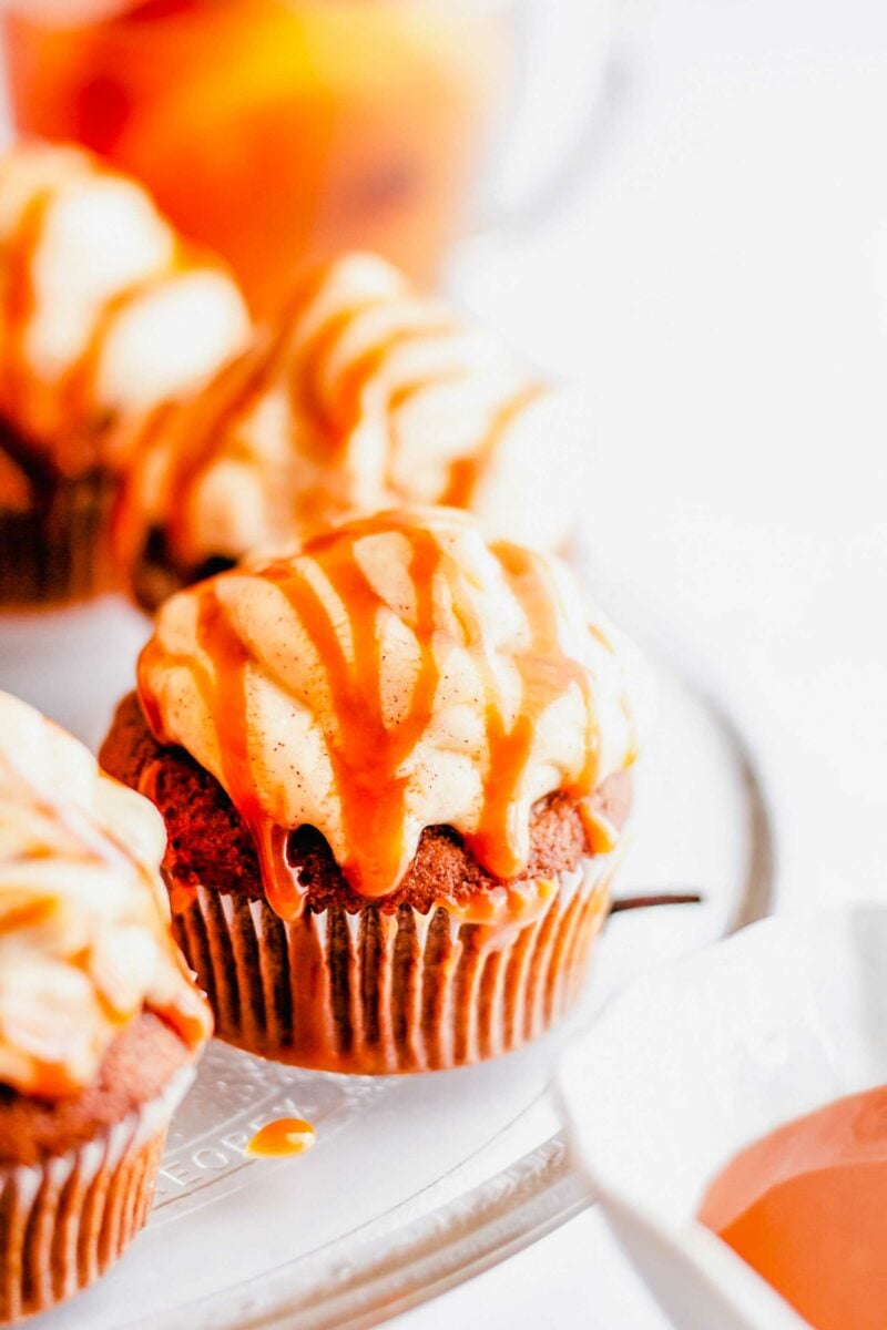 A cupcake is frosted and drizzled with salted caramel sauce. 