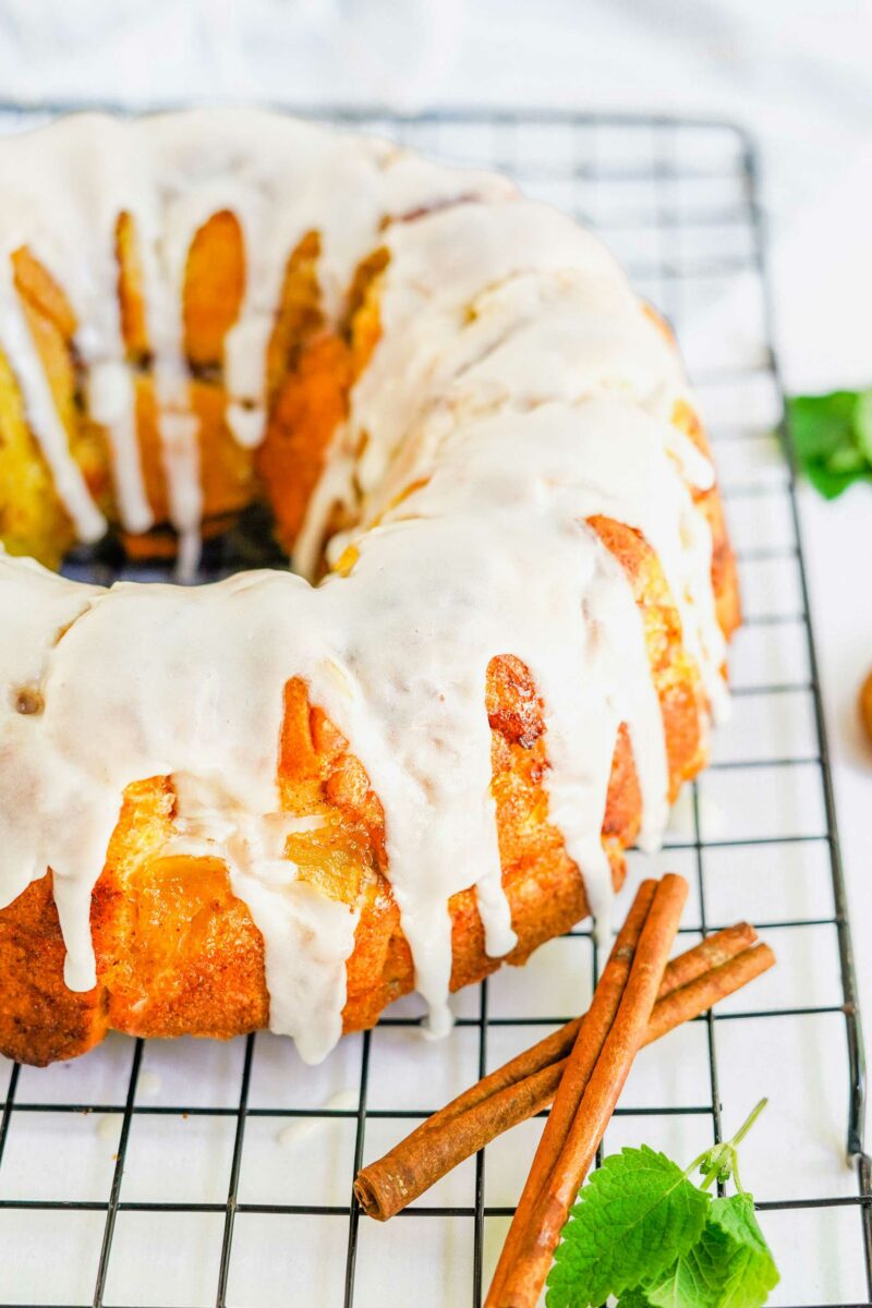 An iced monkey bread ring is placed on a wire cooling rack.