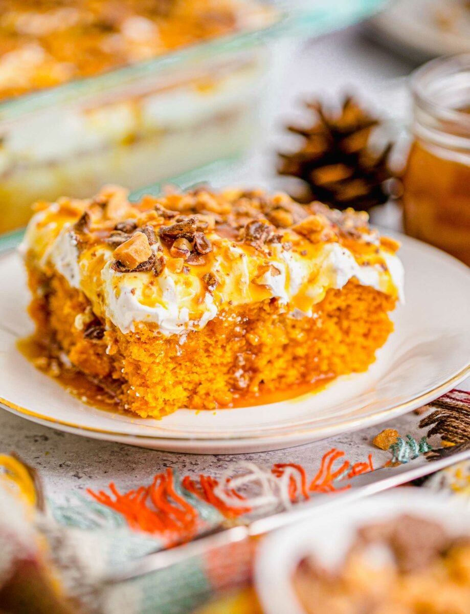 A slice of pumpkin lush cake is presented on a white plate. 