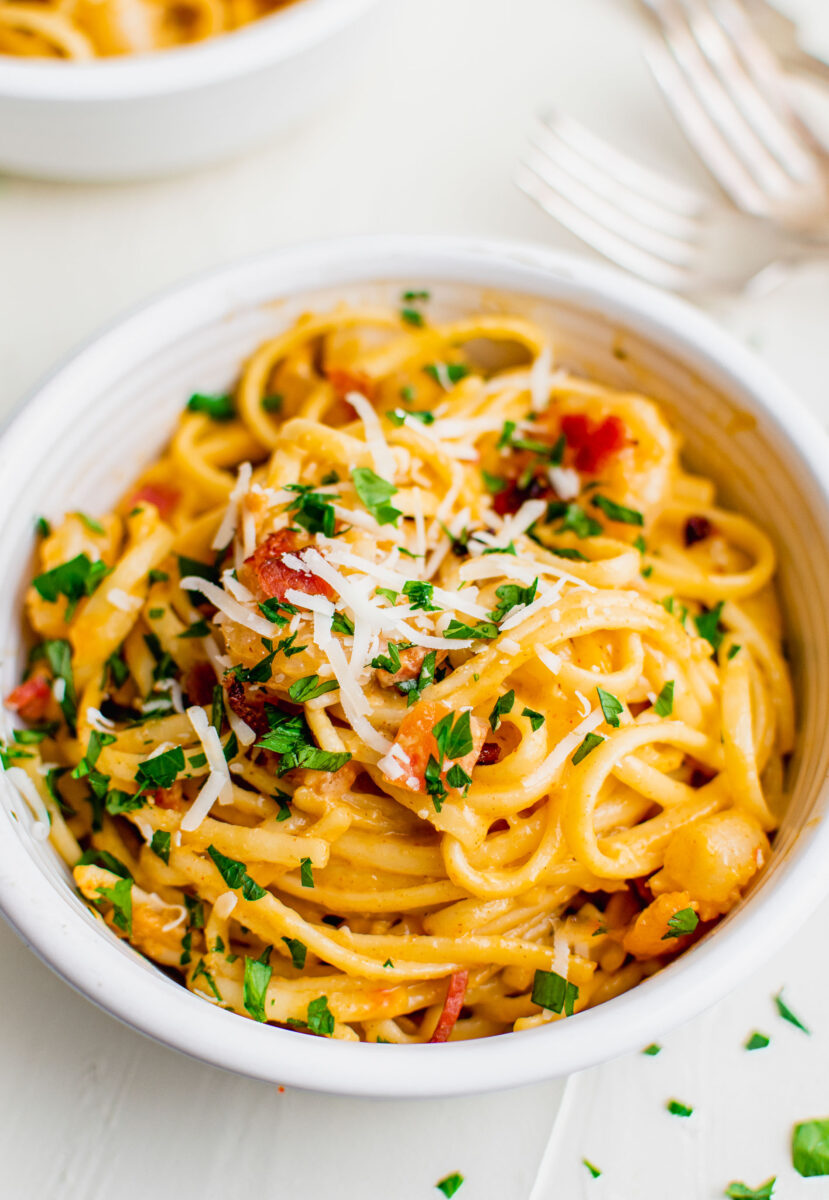 Cheese and parsley is sprinkled atop a serving of pasta.