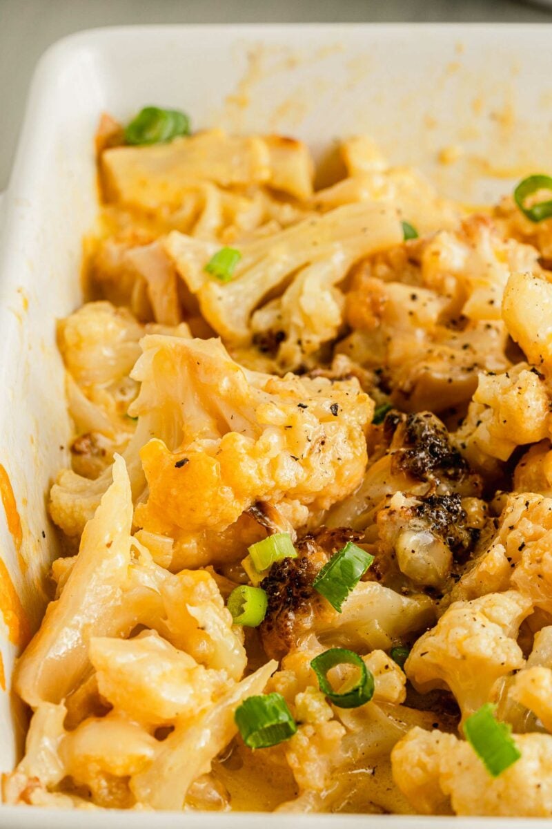 Green onions are placed on top of baked cauliflower. 