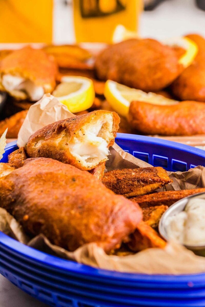 A blue basket is filled with fried fish and chips. 