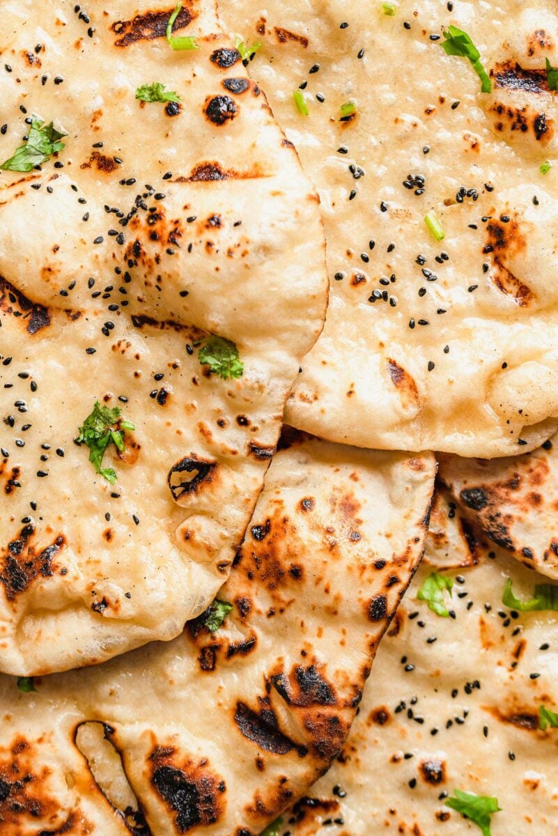Several pieces of cooked and garnished naan are placed on top of each other. 