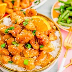 A bowl of orange chicken over white rice