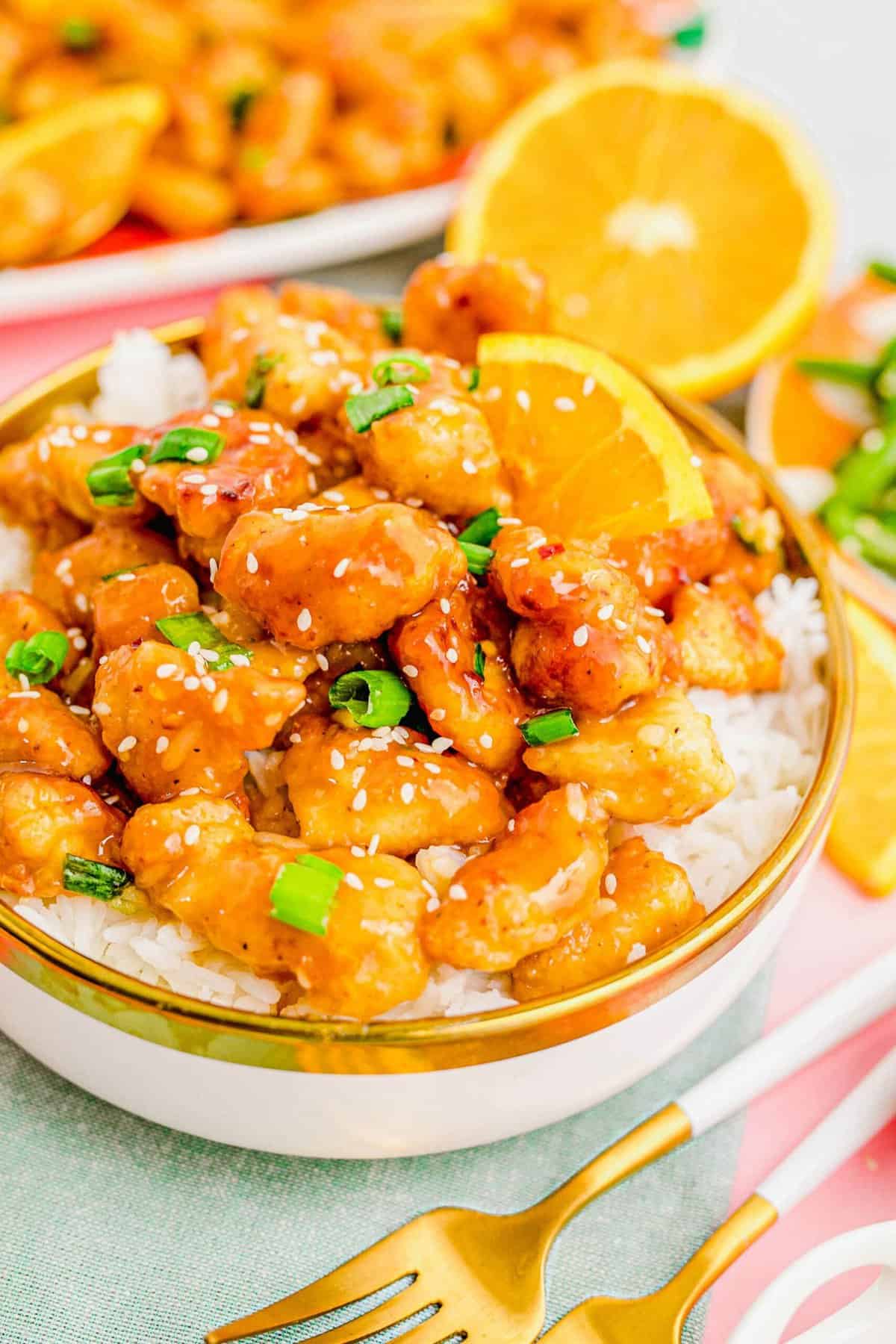 Close up of a bowl of orange chicken and rice