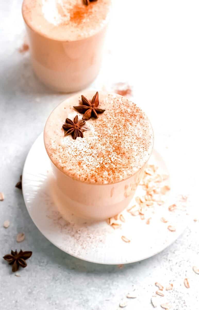 A full glass of pumpkin pie smoothie is topped with cinnamon and two star anises. 