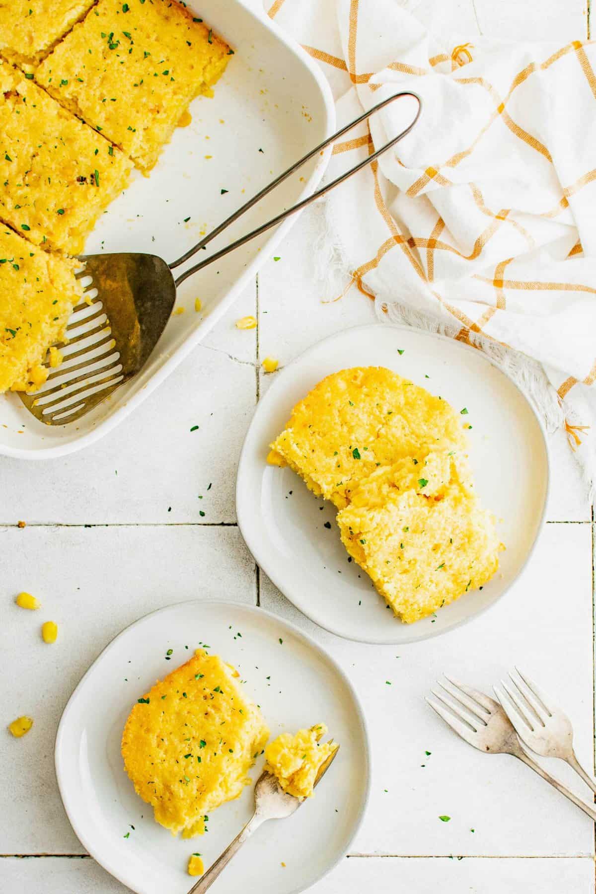 Serving cornbread casserole onto plates.