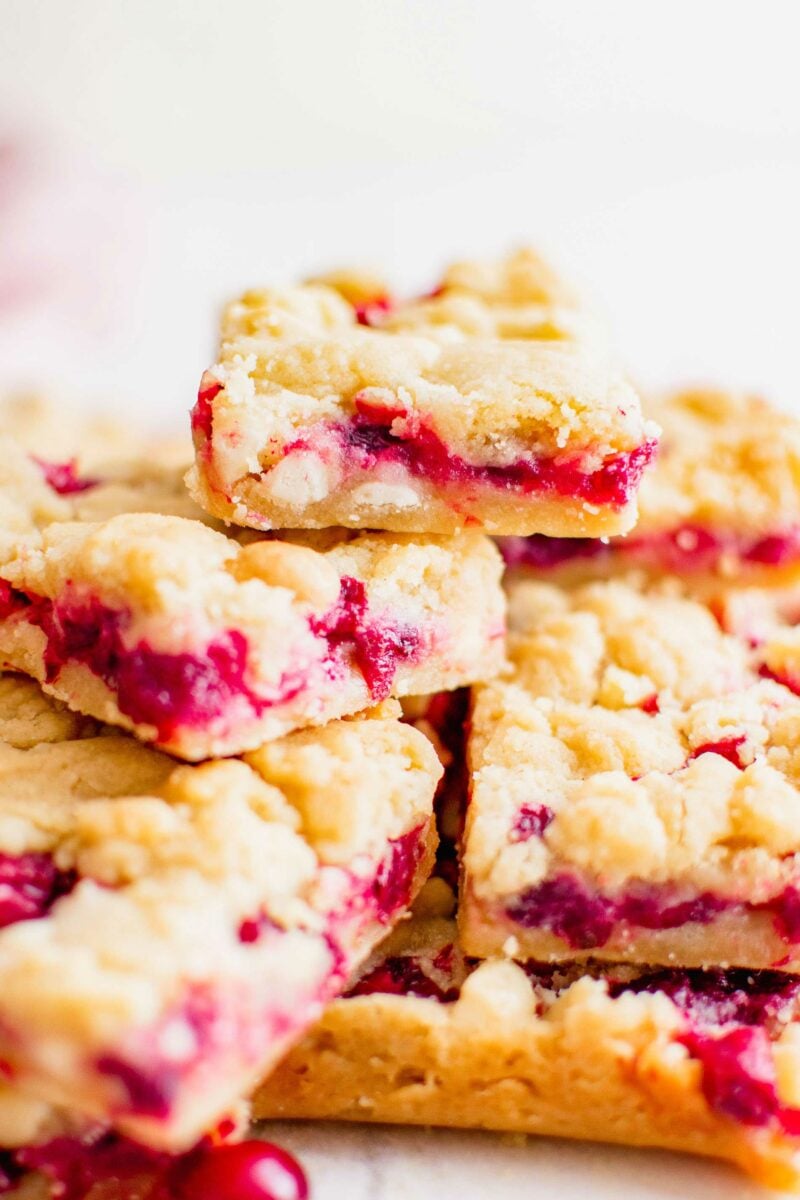 Several cranberry shortbread bars are stacked on top of each other. 