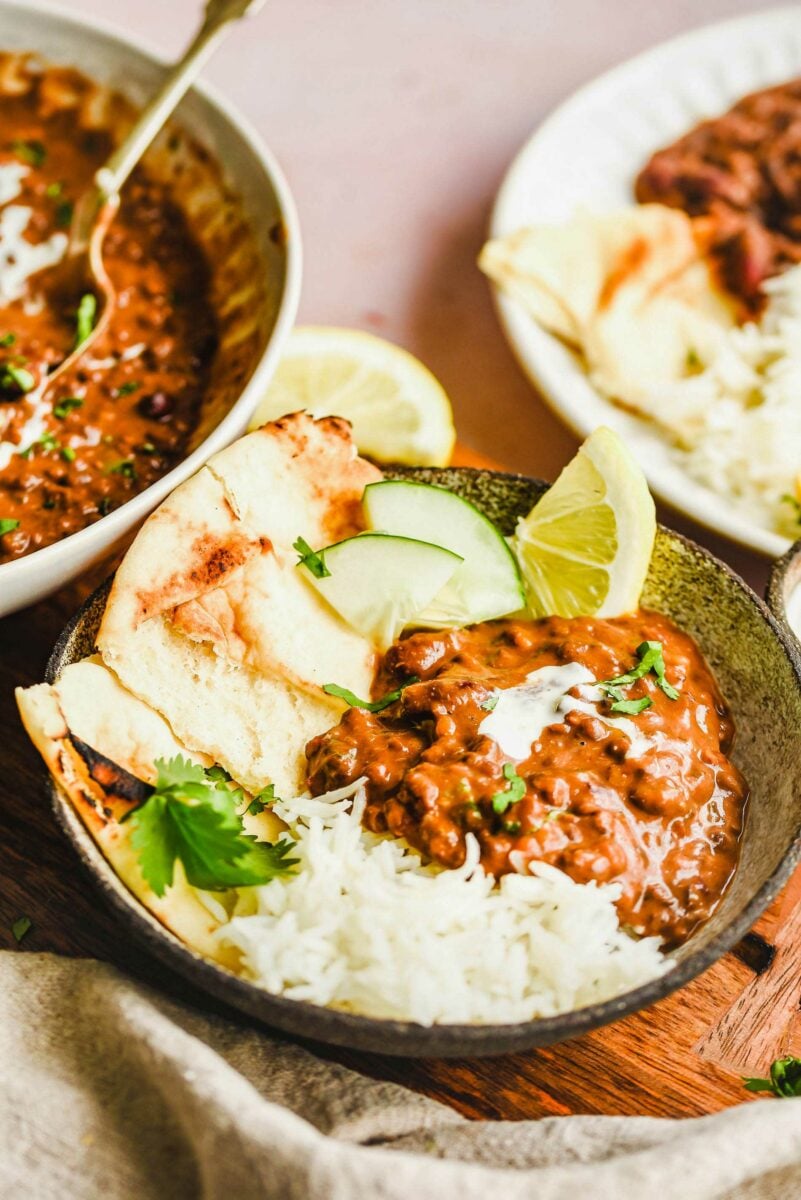 A bowl if filled with dal makhani and sides. 