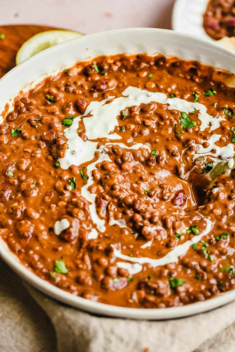 Chopped cilantro is sprinkled across the top of a bowl of dal makhani. 