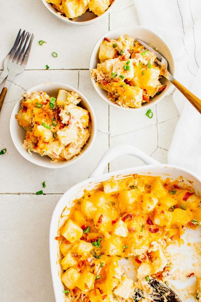 Two full white bowls are placed next to a half full casserole dish. 