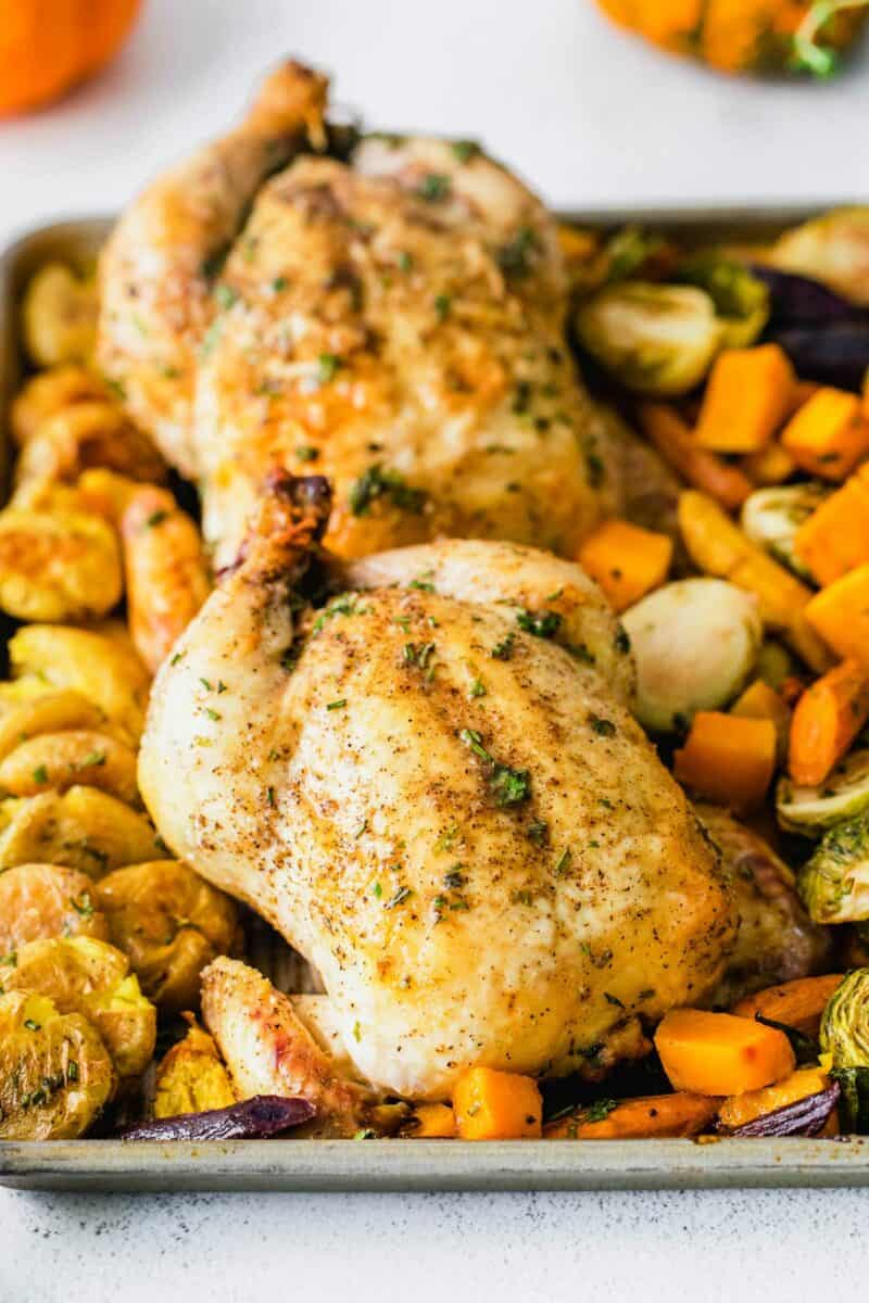 Herbs and butter are drizzled on top of a roasted cornish hen.