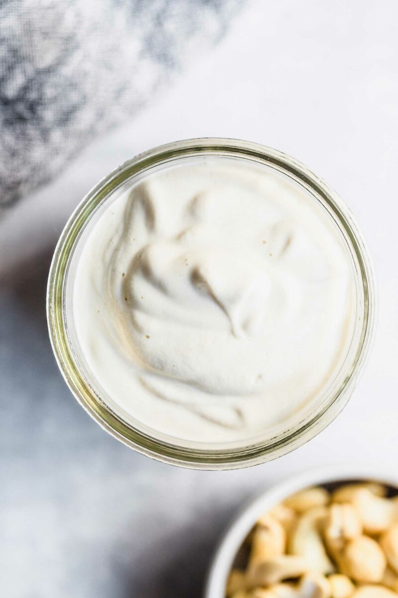 The top of a jar is showing a full portion of cashew cream sauce. 