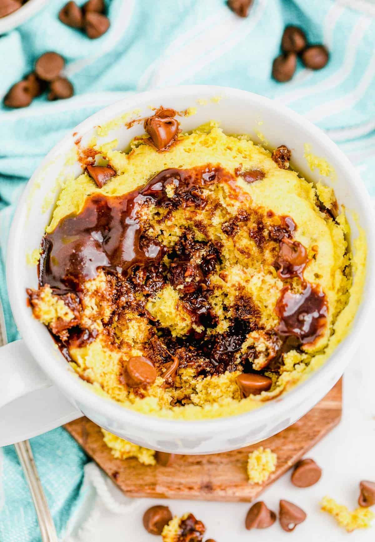 Chocolate chip mug cake with chocolate chips scattered in background