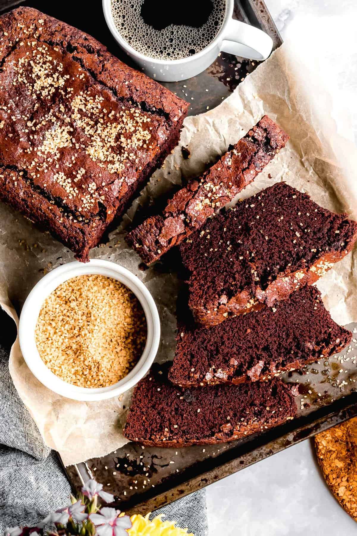 Chocolate cinnamon bread loaf slices with coffee and bowl of cinnamon sugar