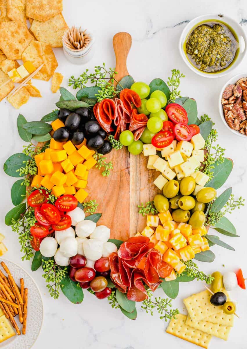 A Christmas charcuterie wreath is presented with crackers and pretzels. 