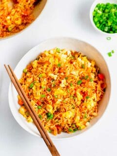 Overhead view of kimchi fried rice in white bowl with wooden chopsticks