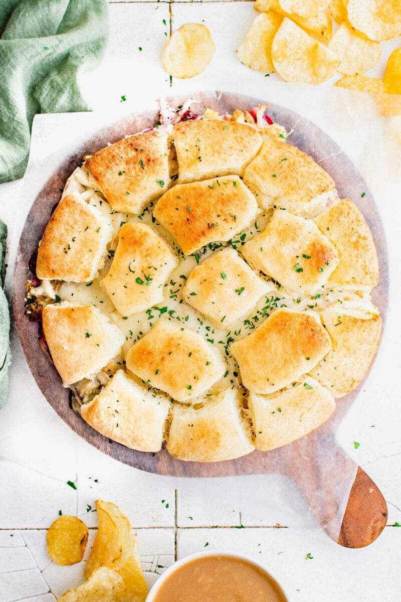 Rolls are topped with fresh herbs in a large circle. 