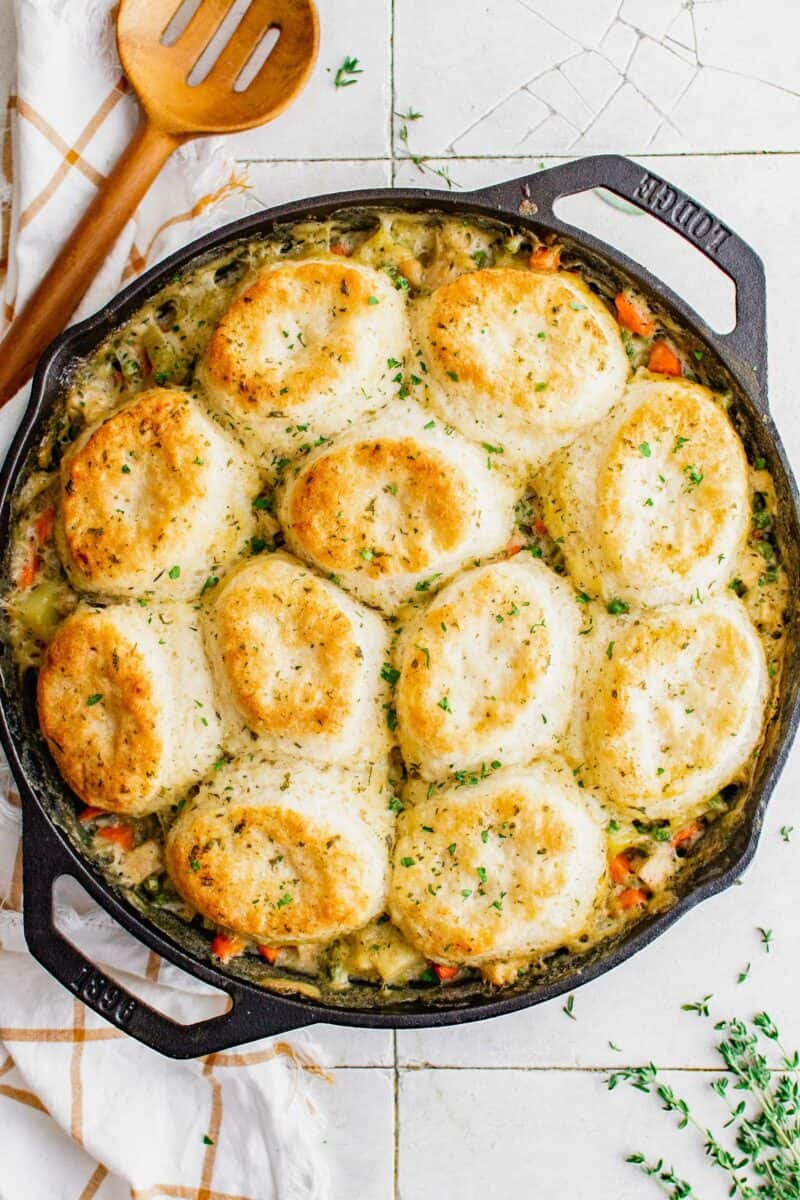 Biscuits are baked on top of a skillet filled with turkey pot pie.