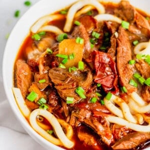 Bowl of Taiwanese beef noodle soup topped with minced green onions